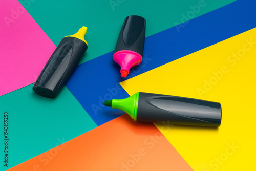 Colorful Highlighters on Vibrant Geometric Background for Creative Stationery Concepts