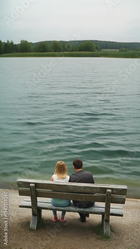 Couple sitting on a bench lake.
