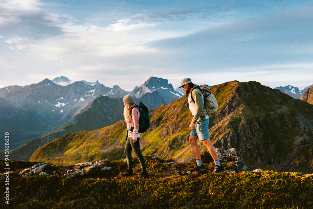 Obraz premium Couple friends climbing mountains in Norway man and woman family travel together healthy lifestyle endurance, people on active hiking summer vacation trip outdoor adventure holidays in Lofoten islands