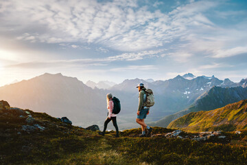Couple friends hiking in Norway man and woman travel together explore mountain trails, active summer vacations healthy lifestyle family trekking outdoor extreme adventure trip in Lofoten islands