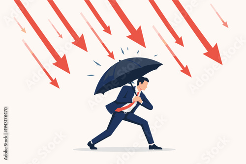Businessman in a suit holding a black umbrella to protect himself from a rain of falling red arrows, representing financial crisis, economic recession, market crash, and risk management concept.