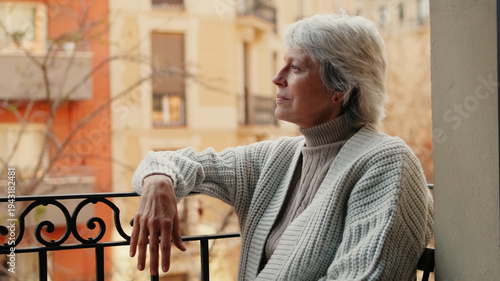 Contemplative Elderly Woman On City Balcony