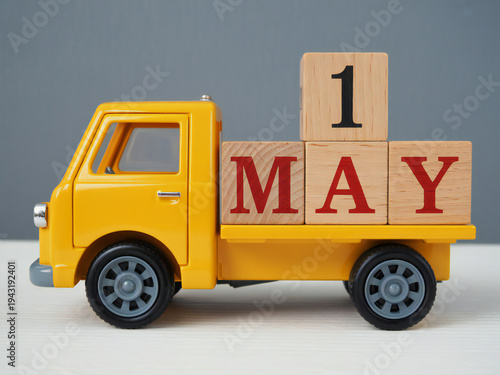 Yellow toy truck with may 1 calendar blocks symbolizing spring and work