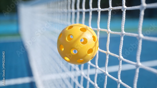 Action Close-up of Yellow Pickleball Flying Over White Net on Blue Outdoor Court