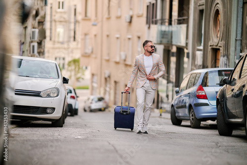 Wallpaper Mural Stylish man walking with suitcase on a city street, traveling for business or vacation, exploring urban life with luggage Torontodigital.ca