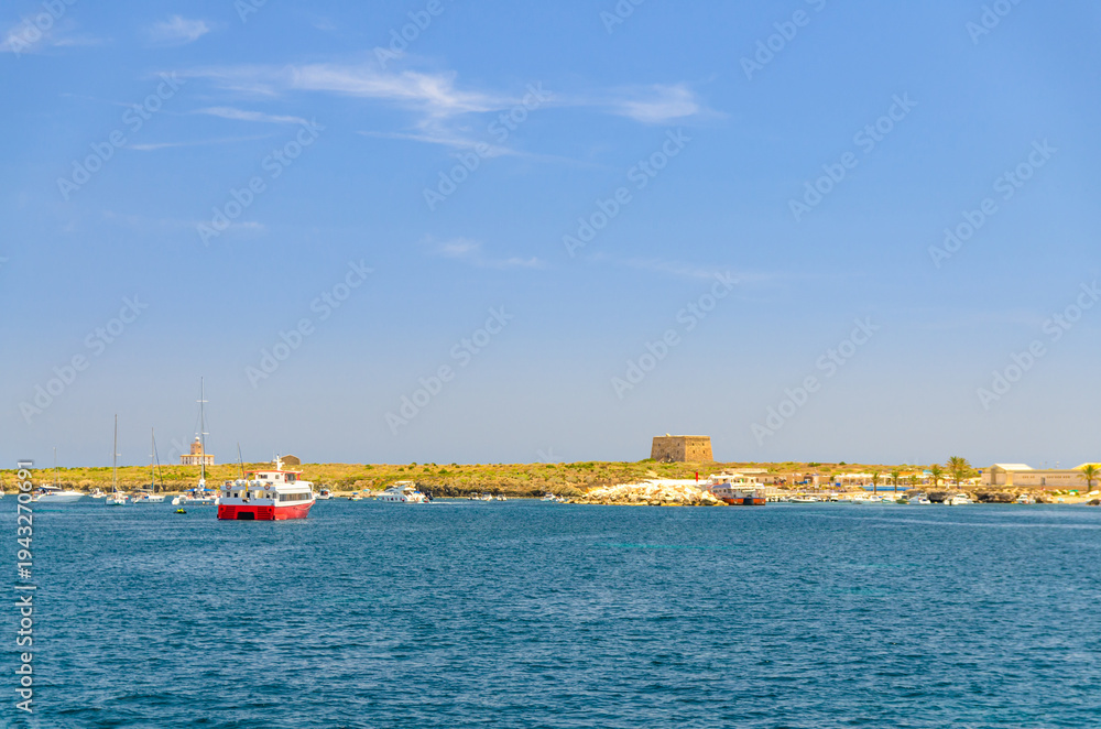 Fototapeta premium Tabarca Island Nueva Tabarca Isla Plana with port, Fort Fuerte building and ferry boats in Mediterranean Sea water in sunny summer day with blue sky, Alicante province, Valencian Community, Spain