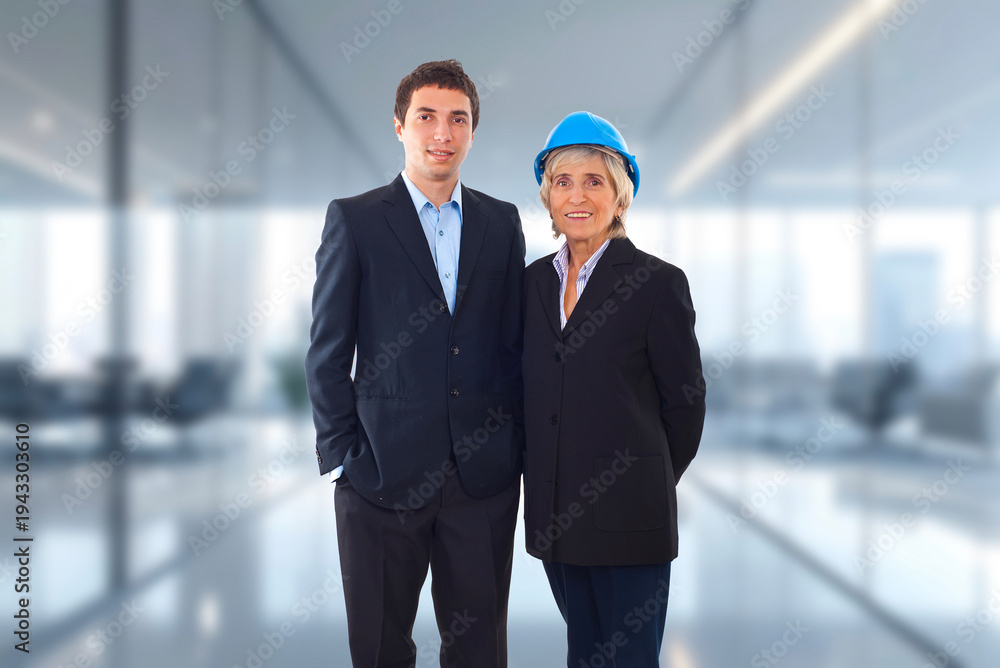 Fototapeta premium Two professionals stand side by side in a modern office space