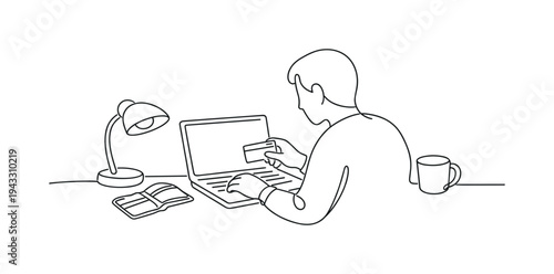 Person seated at a desk entering credit card details on a laptop during an online purchase, wallet open beside the keyboard,