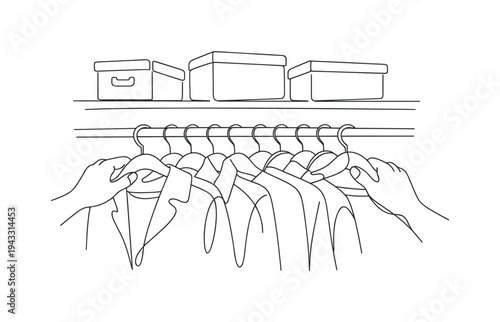 Close view of hands sliding hangers along a clothing rack, mix of jackets and shirts visible, small storage boxes arranged on the