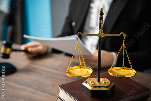 Judge holding a verdict in one hand and a gavel in the other, with scales in view, symbolizing justice, authority, and legal decision-making.