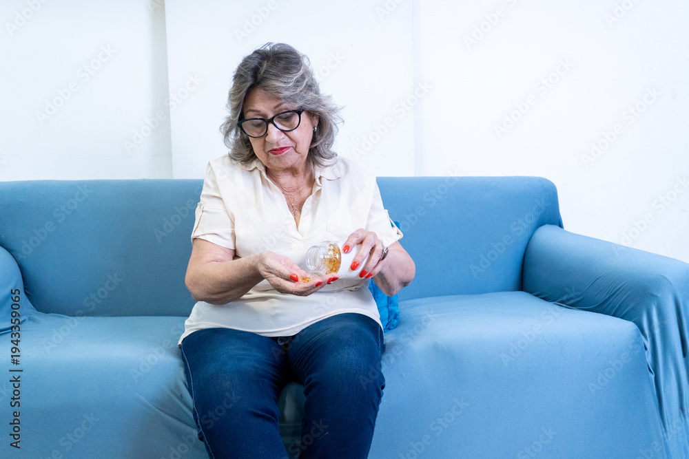 Obraz premium Senior woman taking daily medicine pills for health