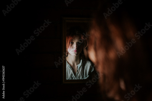 Young Woman Looking at Herself in Mirror