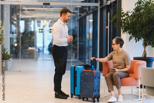 Obraz na plátně Hotel guest talking with bellboy in lobby