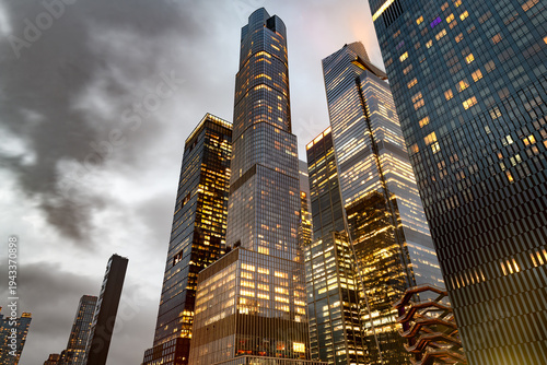 Modern glass skyscrapers of Hudson Yards rise into a cloudy evening sky in Manhattan, New York.