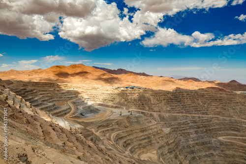 A vast open pit copper mine features deep terraces carved into the desert landscape of northern Chile.