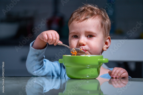 Little child eating nutritious fruit and vegetable mix rich in natural vitamins.