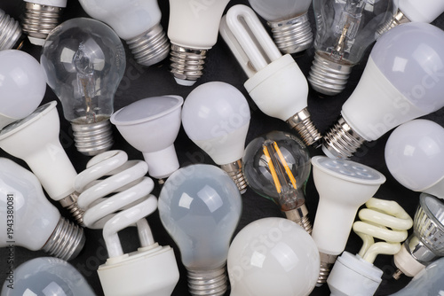 Close up of different kinds of light bulbs on black background, top view
