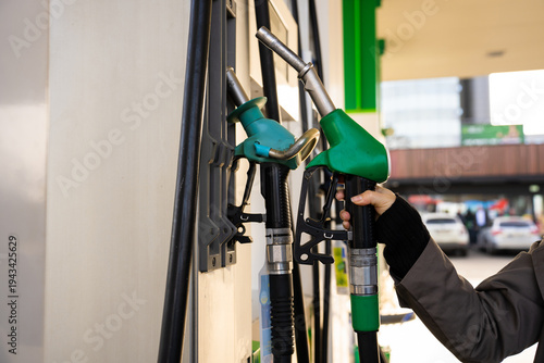 Wallpaper Mural Fuel pump nozzle in hand while refueling vehicle Torontodigital.ca