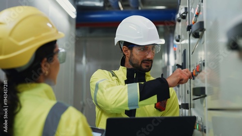 Foto Technician and electrician use computer and tablet diagnostics to analyze control panels, optimize energy use and prevent downtime