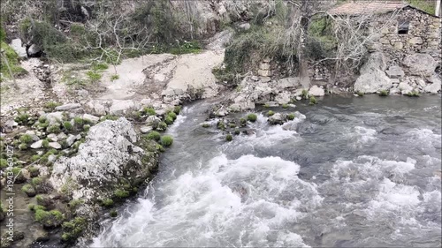 Water stream of a river running through a mountain with a ruin of a mill, Sousa river valley in Serras do Porto in Portugal