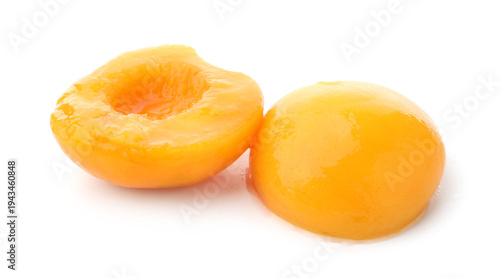 Halves of tasty canned peach isolated on white