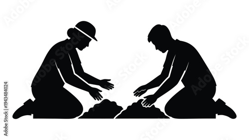 Two people kneeling and working on a pile of dirt