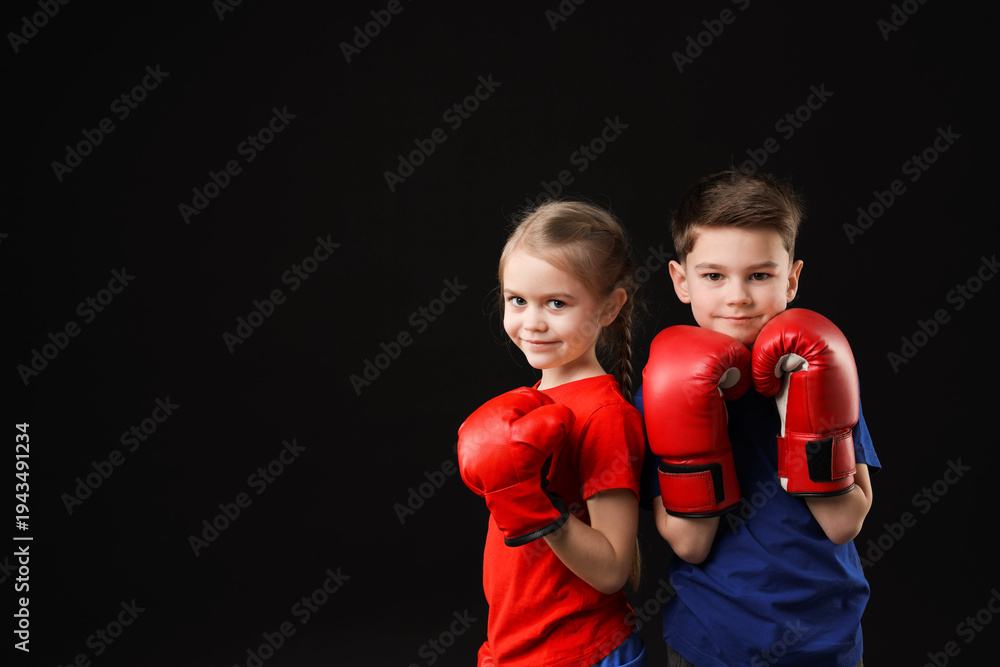 Naklejka premium Cute kids in boxing gloves on black background, space for text