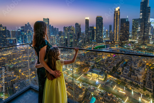 Photos A mother and her daughter standing on a balcony and looking at the skyline view