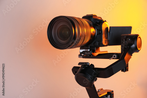 Photography Gimbal stabilizer with camera on color background, closeup
