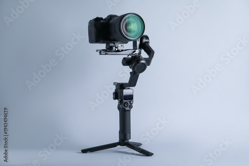 Фотография Gimbal stabilizer with camera on light background