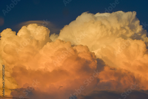 Vast orange clouds dominate the deep blue sky during golden hour.