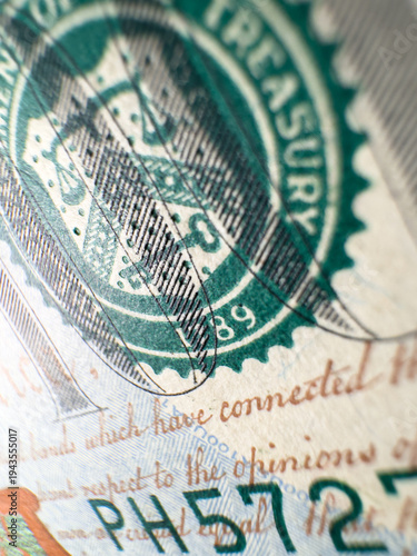 Detailed macro image shows the green US Treasury seal and serial number on American paper currency. Suitable for finance, banking, security, and economic concept illustrations.