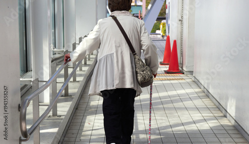 春の昼の名古屋の栄の繁華街で歩く一人のシニア女性の姿
