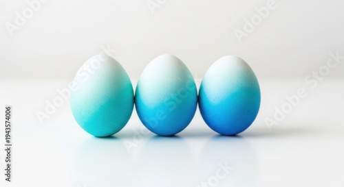 Three blue eggs in a row on white background