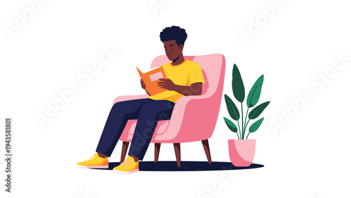 Man sits comfortably in a pink armchair reading a book, enjoying a quiet moment of education and leisure at home.