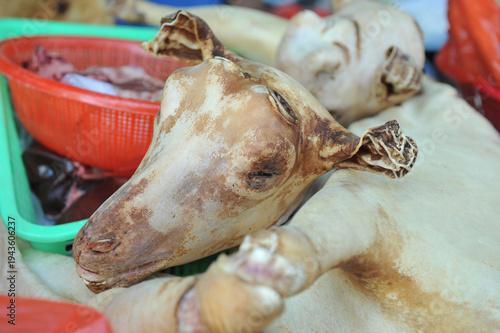 фотографія A ram's head and carcass on a market stall