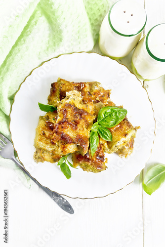Rolls of zucchini with meat in plate on light board top