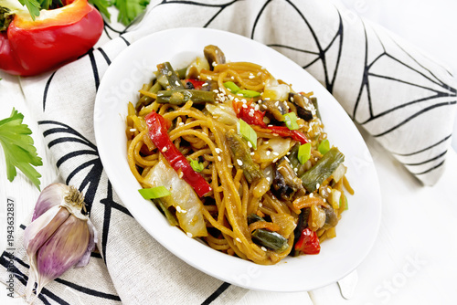 Spaghetti buckwheat with vegetables in plate on white board