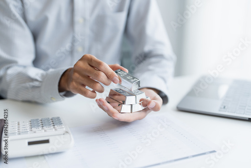Silver bar Trading business man hand offering silver Investment financial report Trading Pure silver precious metals investment  on the stock exchange Rising prices.