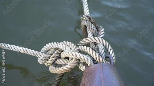 Rope anchored the boat into the harbor.Mooring rope and bollard