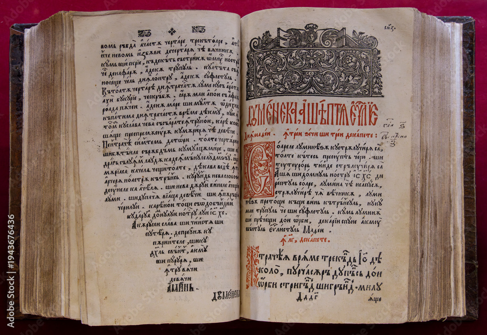 Naklejka premium An antique Gospel book, likely printed in the 17th or 18th century, featuring ornate Cyrillic text and detailed woodcut engravings, at the Saambata de Sus monastery - Romania