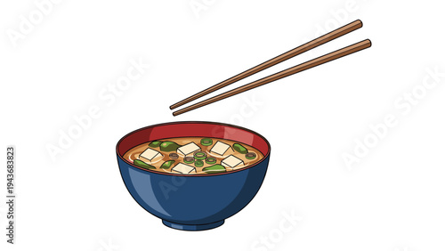 Bowl of steaming miso soup with tofu cubes and green onions is shown with a pair of wooden chopsticks resting above it.