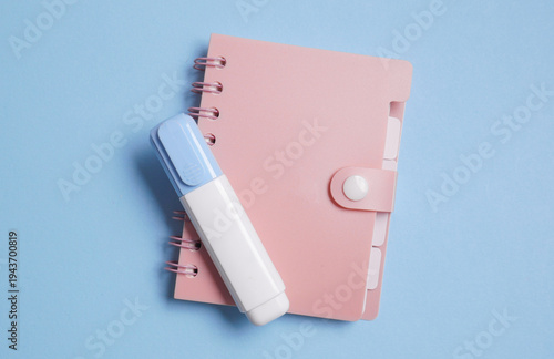 Notebook diary with corrector on blue background