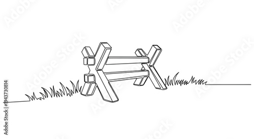 Wooden anti-tank barrier in grassy field  