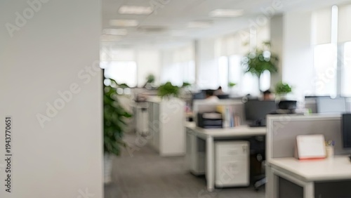 Blurred modern office interior with cubicles and natural light.