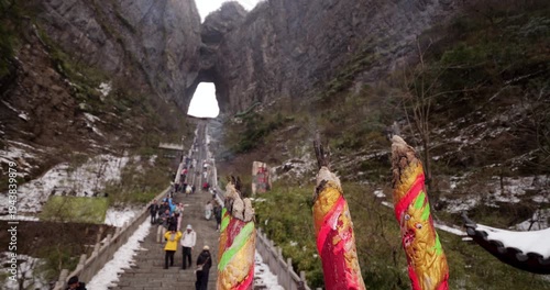 Selective focus on thick, giant joss sticks smoldering at Tianmen Mountain. Wisps of white incense smoke rise gently against blurred background of 999 Steps and Heaven's Gate arch.