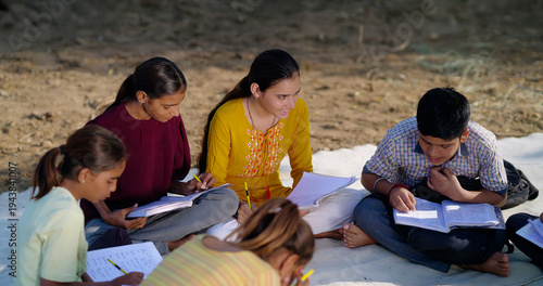 Bild auf Leinwand Indian villager girl boy sitting on mat do study read book outdoor rural area ground place