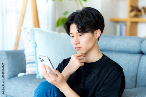 Foto スマホを操作する若い男性
