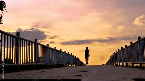 Silhouette of young man running sprinting on road. Fit runner fitness runner during outdoor workout with sunset background. 4K