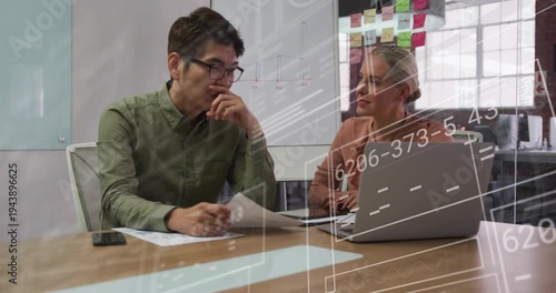 Man pointing at laptop, woman typing, data overlays aligning with papers, ending business review